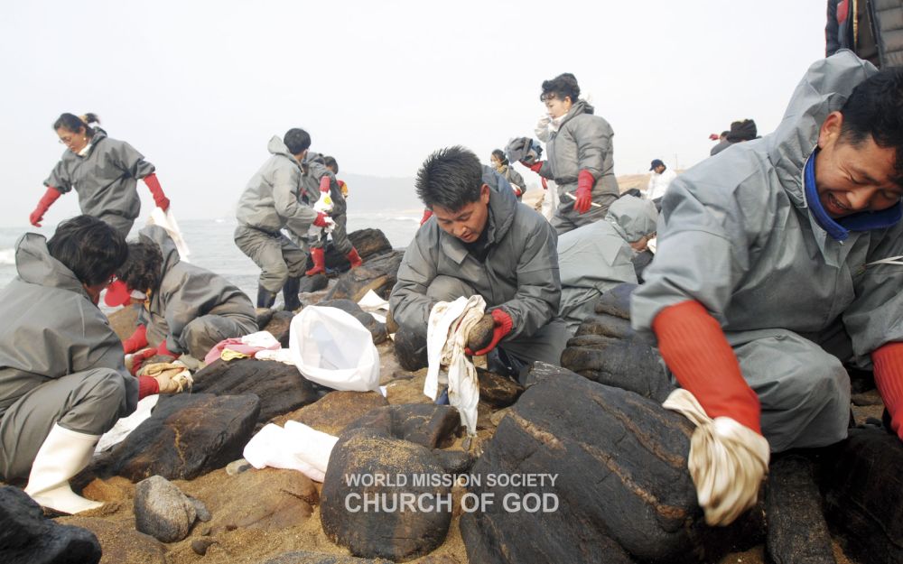 Los miembros de la Iglesia de Dios limpian el derrame de petróleo de 2007 en la playa Hakampo en Taean, Chungnam, Corea