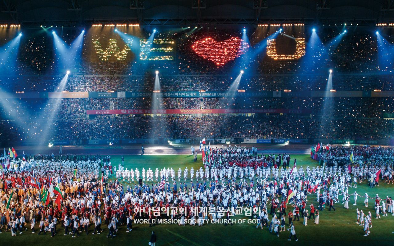 En la ceremonia de apertura de las Universiadas de Daegu 2003, los Alentadores Aurah de la Iglesia de Dios presentan una actuación con linternas de WE ♥ U .
