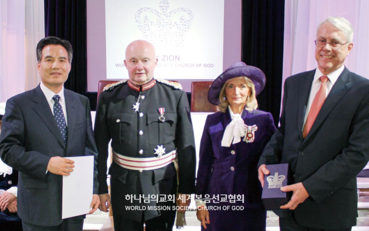 At the Queen’s Award for Voluntary Service ceremony, Pastor Kim Joo-Cheol, General Pastor of the Church of God (left), attends alongside the Governor of Greater Manchester and other dignitaries.