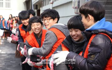 봉사에 참여한 광주서구 하나님의 교회 학생들이 연탄을 옮기며 환하게 웃고 있다.